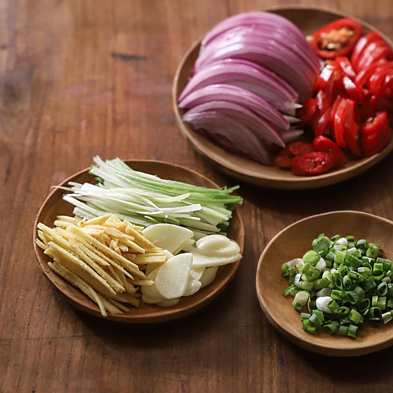 홍고추는 어슷하게 썰고 쪽파는 송송 썰어주세요. 적양파는 길이대로, 대파와 생강은 4cm 길이로 채를 썰고, 마늘은 편을 썰어 주세요.