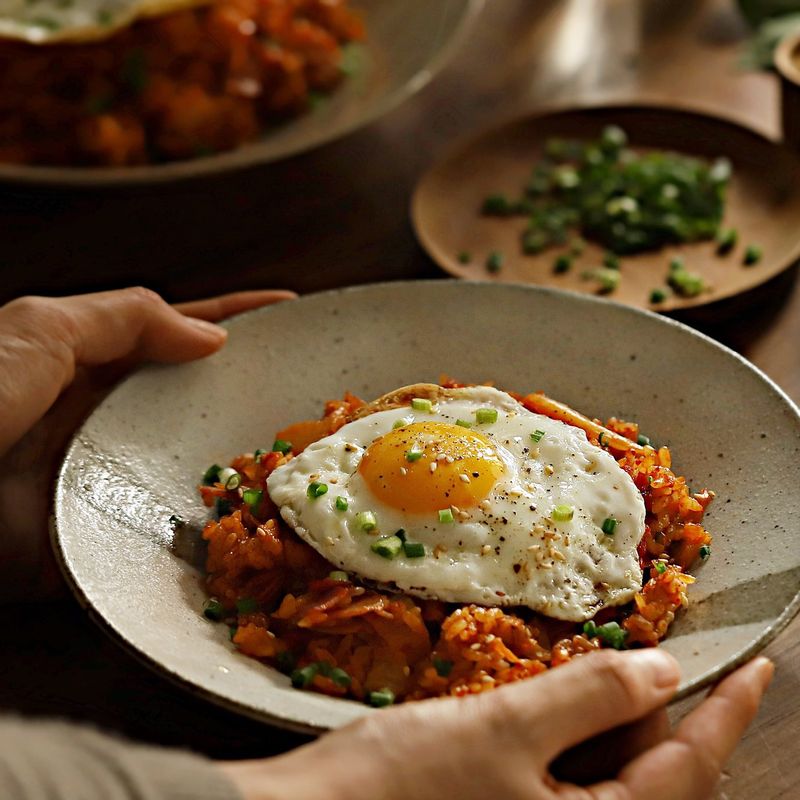 그릇에 김치볶음밥을 담고, 통깨와 실파를 뿌려주세요. 달걀프라이를 곁들이면 더욱 맛이 좋아요.