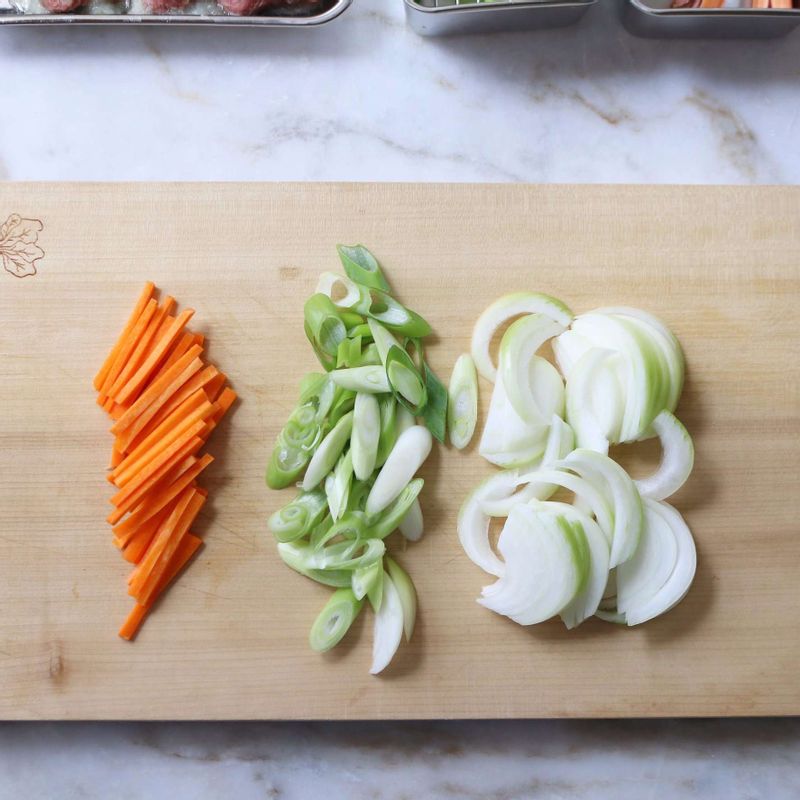 양파와 당근은 굵게 채썰고, 대파는 어슷하게 썰어 양념한 고기와 섞어주세요.