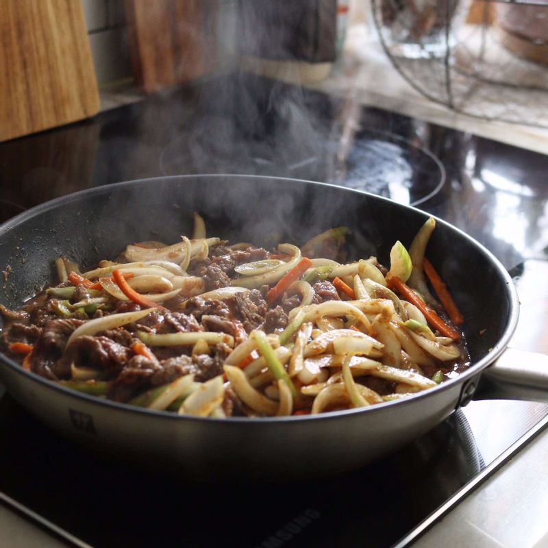 달군 팬에 양념한 쇠고기와 야채를 넣어 볶다가, 고기와 야채가 익으면 불을 끄고 참기름을 뿌려주세요.