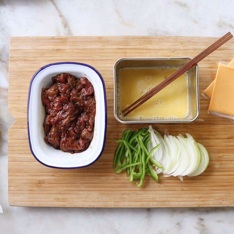 쇠고기는 키친타올로 핏물을 제거하고, 먹기 좋은 크기로 썰어 불고기양념에 10분 정도 재워주세요. 양파와 파프리카는 채를 썰어주세요.