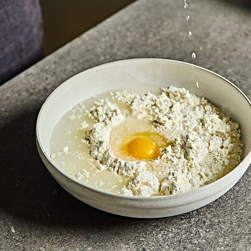 볼에 부침가루와 물, 달걀을 넣어 멍울 없이 잘 풀어준 후 배추김치와 청양고추, 오징어를 넣어 섞어주세요.
(반죽에 약간의 고춧가루를 넣어주시면, 좀 더 먹음직스러운 색의 김치전을 만들 수 있어요)
(물은 한 번에 많이 붓지 말고, 조금씩 넣어가며 반죽을 섞어야 재료가 잘 섞인답니다)