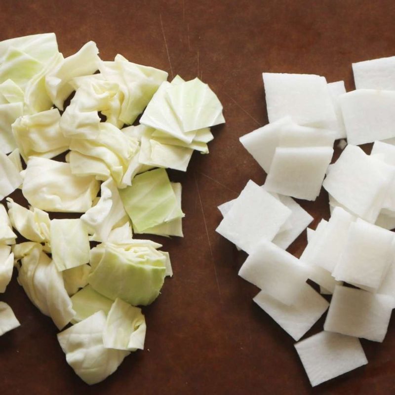 무는 한입 크기로 나박하게 썰고 양배추는 겉잎을 떼어내고 무와 비슷한 크기로 썰어주세요. 쪽파는 4cm 길이로 잘라주세요.