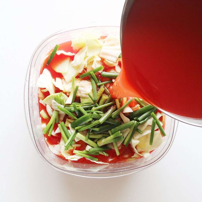 김치통에 무, 양배추, 쪽파를 넣고 국물을 부은 후 하루 동안 실온에 두고 숙성해주세요.