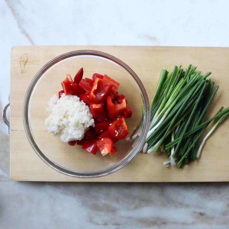 파프리카는 꼭지와 씨를 제거한 뒤 굵직하게 썰고, 홍고추도 꼭지만 제거한 뒤 툭툭 썰어 쌀밥과 함께 블렌더에 넣어 곱지 않게 갈아주세요. 쪽파는 2등분로 잘라주세요.