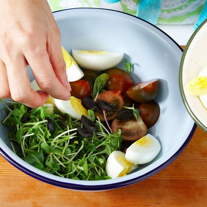그릇에 새싹 채소와 토마토, 삶은 달걀, 올리브를 넣어 가볍게 섞은 뒤 드레싱의 절반을 넣어 살짝 버무려주세요.
TIP. 삶은 달걀을 버무리면 모양이 으스러지지만, 달걀 노른자의 고소함이 고루 퍼져 요리 맛을 더 좋게 합니다. 모양이 신경쓰인다면 삶은 달걀을 마지막에 그릇에 담으세요.
