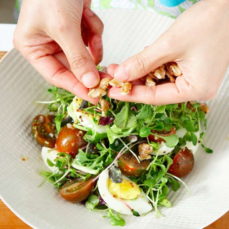 호두를 손으로 부수어 뿌린 뒤 남은 드레싱을 모두 부어주세요.