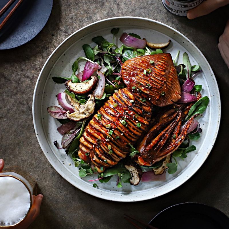 접시에 어린잎새싹을 깔고 통오징어고추장구이를 올린 후, 송송 썬 실파와 통깨를 뿌려주세요. 오징어에 칼집을 넣은 곳을 먹기 좋게 잘라 맛있게 즐겨주세요.
(기호에 따라 버섯과 양파를 볶아 함께 곁들여주세요)