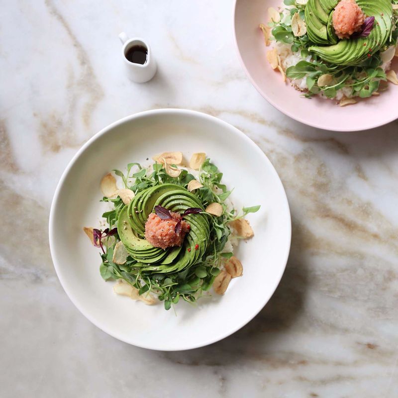 그릇에 밥을 담고 어린잎채소-아보카도-명란알 순으로 올리고, 마늘칩을 뿌린 후 참기름과 후춧가루, 통깨를 뿌려주세요.