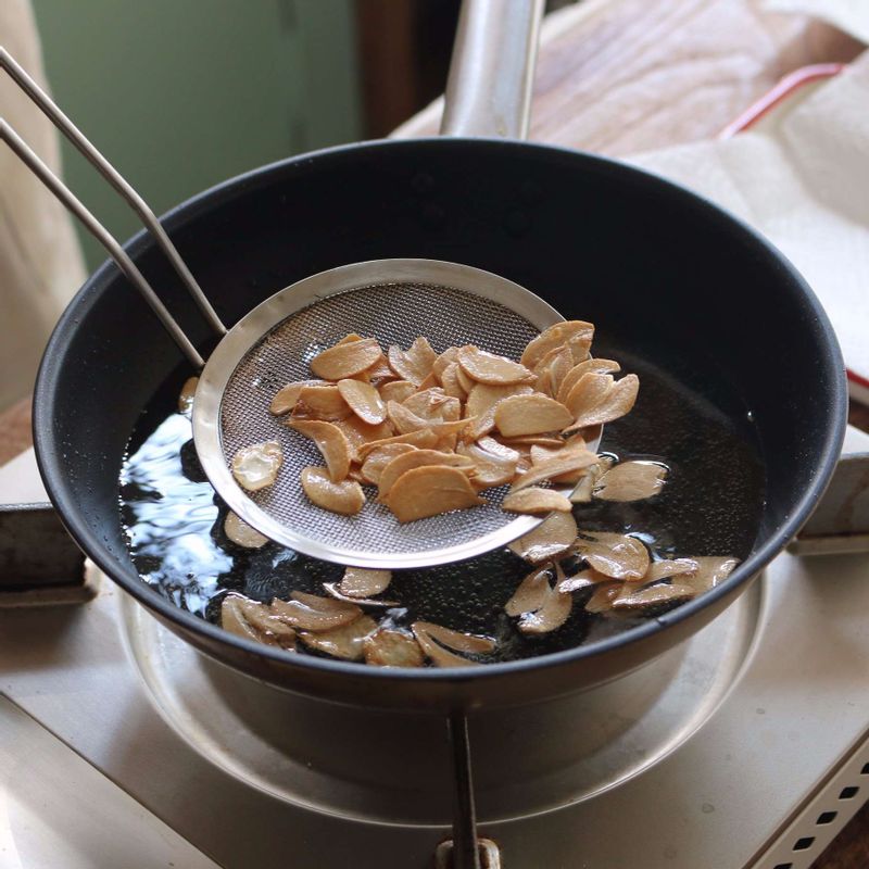 팬에 기름을 넉넉히 두르고, 160도로 달군 후 마늘을 노릇하게 튀겨주세요.