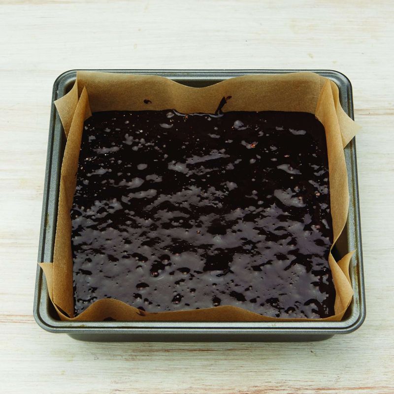 유산지를 깔아 놓은 정사각팬에 반죽을 채우고, 스크래퍼를 이용해 윗면을 평평하게 해주세요. 미리 예열한 180℃ 오븐에 넣고 25~30분간 구운 다음 식힘망에 올려 식혀주세요.