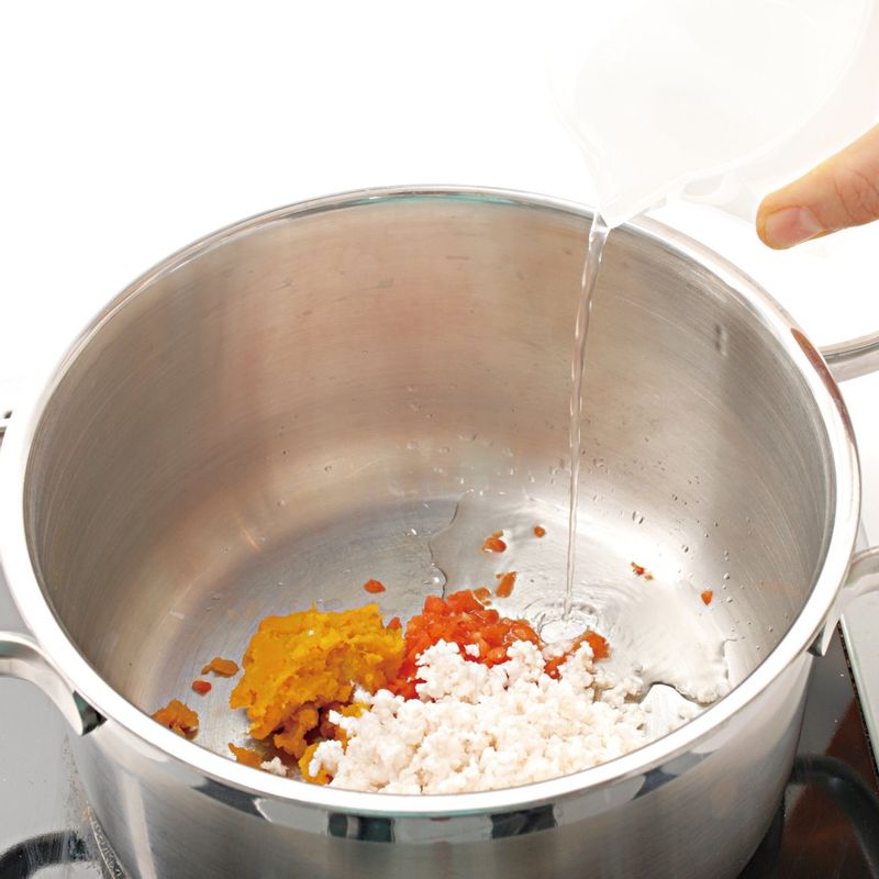 STEP5와 으깬 단호박, 다진 파프리카를 넣고 물(육수)을 부은 다음 센 불에서 저어 가며 끓이세요.