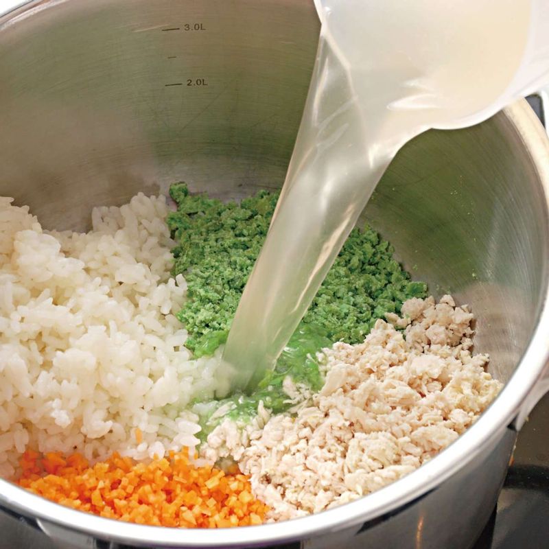 다진 당근과 닭고기, 으깬 완두콩, 진밥을 넣고 물(육수)을 부은 다음 센 불에서 저어 가며 끓이세요.