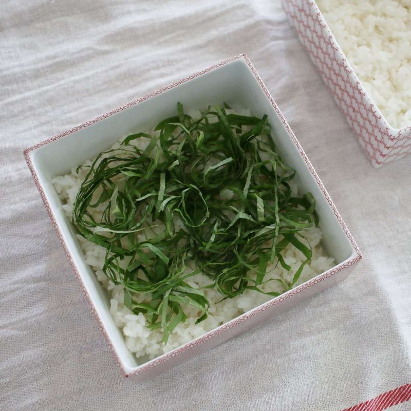 단촛물 재료를 모두 볼에 넣고 전자레인지에 1분간 돌려 설탕을 완전히 녹인 후 따뜻한 밥과 섞어주세요. 그릇에 밥을 담고 깻잎을 고루 올려주세요.