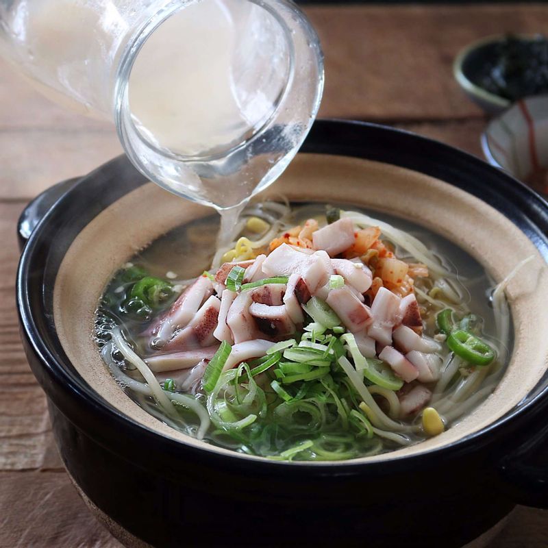 그릇에 밥을 담고 삶은 콩나물을 올린 후 뜨거운 육수를 붓고 대파와 청양고추, 오징어, 김치, 고춧가루를 올려주세요.