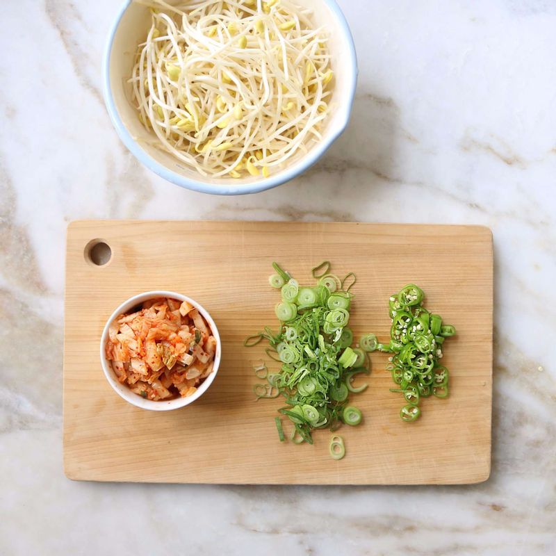 콩나물은 깨끗이 씻어 다듬고, 배추김치는 속 양념을 털어내고 잘게 잘라주세요. 청양고추와 대파는 송송 잘라주세요.