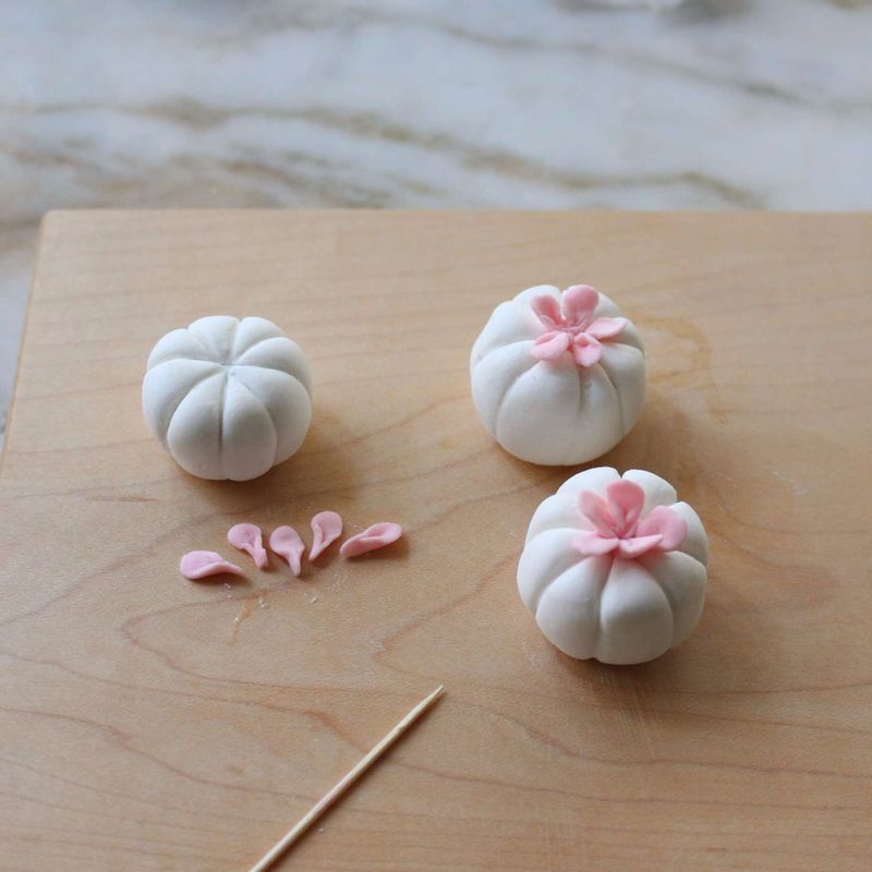 호박모양의 송편은 소를 넣고 동그랗게 굴린 반죽을 나무꼬치로 눌러가며 호박모양으로 만들어주세요.
(딸기가루로 색을 낸 반죽을 올려 꽃잎을 만드셔도 돼요)