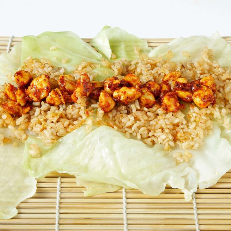 김발 위에 양배추 잎 2장을 깔고, STEP5의 현미밥을 얇게 깐 뒤 닭고기를 올려 꼭꼭 누르면 돌돌 말아주세요.