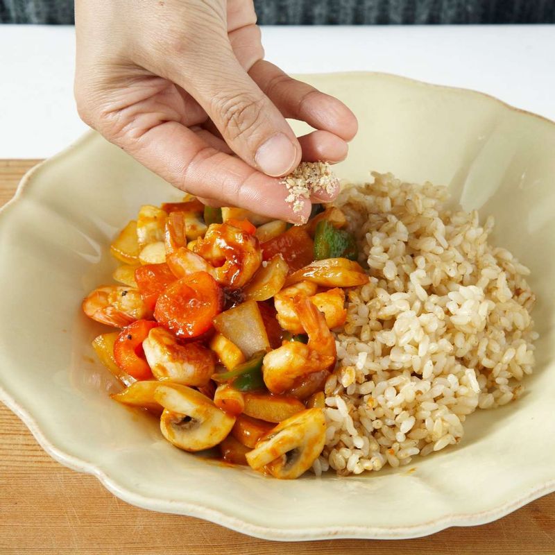 밥 위에 새우파프리카볶음을 올리고 깨소금을 뿌려 마무리하세요.