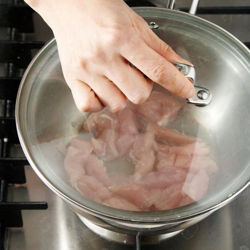 냄비에 물 4큰술을 두른 뒤 닭고기를 먼저 넣고 뚜껑을 덮어 익혀주세요.
