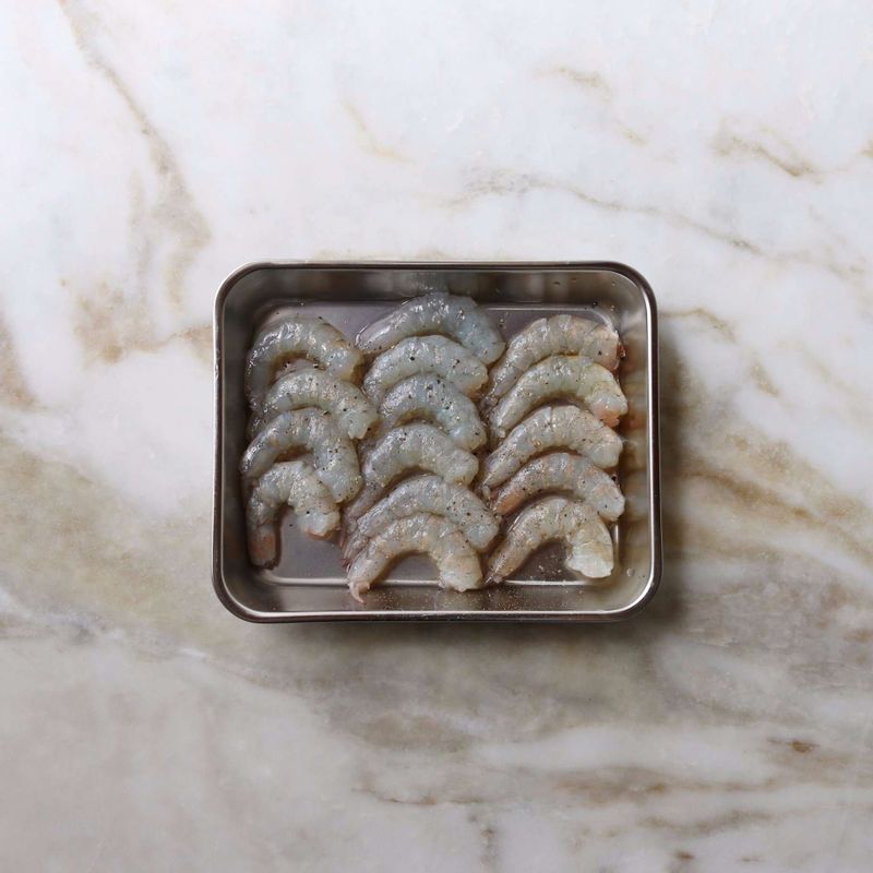 새우는 껍질을 벗기고, 나무꼬치로 내장을 빼낸 후 밑간 재료를 뿌려 10분 정도 밑간해주세요.