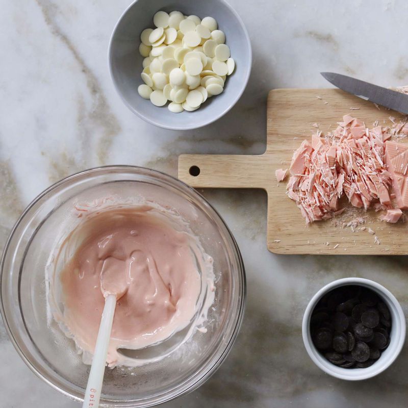 볼에 각각 다크, 핑크, 화이트 초콜릿을 잘게 잘라 넣어주세요.
다른 볼에 60도 이하의 따뜻한 물을 넣고 린넨을 깐 후, 초콜릿이 담긴 볼을 올려 저어주며 중탕으로 녹여주세요. (물이 초콜릿에 들어가지 않도록 주의해서 저어주세요)