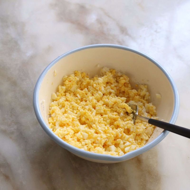 삶은 달걀의 흰자는 잘게 다지고, 노른자는 포크로 으깨 준 후 볼에 담아 달걀양념 재료를 넣어 섞어주세요.