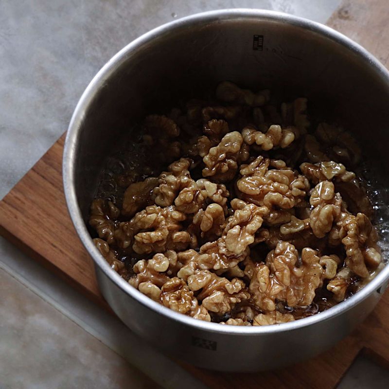 냄비에 시럽 재료를 넣고, 수저로 젓지 않고 중간불에서 설탕이 녹을 때까지 끓여 시럽을 만들어주세요. 완성된 시럽에 데친 호두를 넣고 2분 정도 섞으면서 졸인 후 체에 밭쳐주세요.
