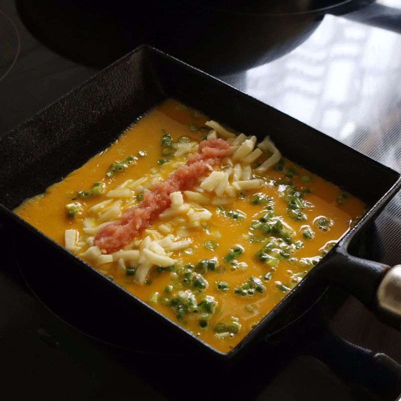 중약불로 달군 팬에 약간의 식용유를 두르고 노른자를 국자로 떠 넣은 후, 피자치즈와 명란알 1큰술을 일자로 올려 윗면이 반쯤 익으면 돌돌 말아주세요.