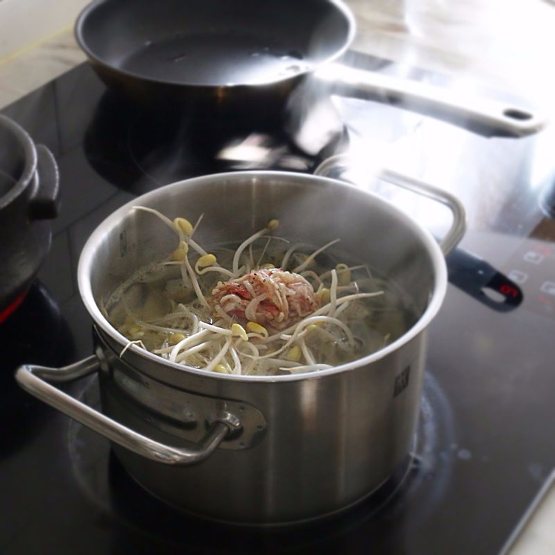 무가 익으면 국물양념 재료와 콩나물, 양파를 넣고 끓이다가 굴과 대파, 홍고추와 청양고추를 넣고 1분 정도 끓여주세요.