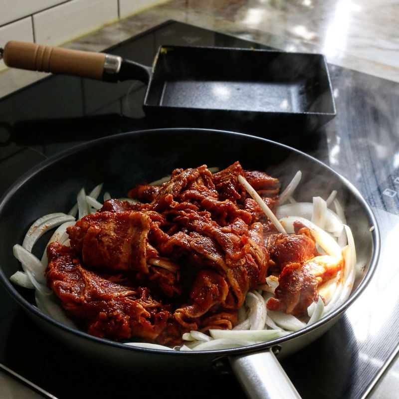 팬에 약간의 기름을 두르고, 양념한 돼지고기와 양파를 넣고 볶아주세요.