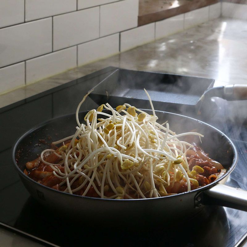 돼지고기가 익으면 콩나물과 대파, 청양고추, 홍고추를 넣어 콩나물의 비린내가 나지 않을 때까지 볶다가 마지막에 참기름을 넣고 불을 꺼주세요.