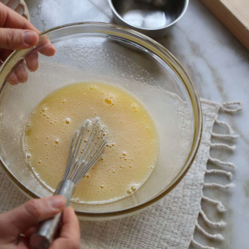 볼에 달걀을 넣고 30초간 거품기로 달걀을 풀어주세요. 설탕을 조금씩 넣으면서 섞은 후 포도씨유를 넣어 섞어주세요.
