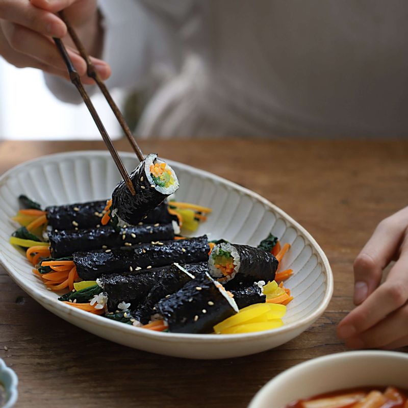 꼬마김밥 표면에 참기름을 바르고 통깨를 뿌린 후 겨자소스를 곁들여주세요.
