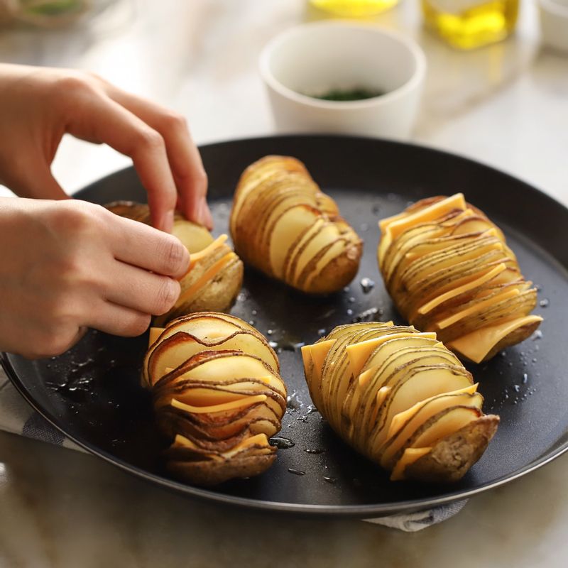 구운 감자의 칼집 사이사이에 체더치즈를 넣고 오븐에서 15~20분 정도 치즈가 녹을 때까지 구워주세요.