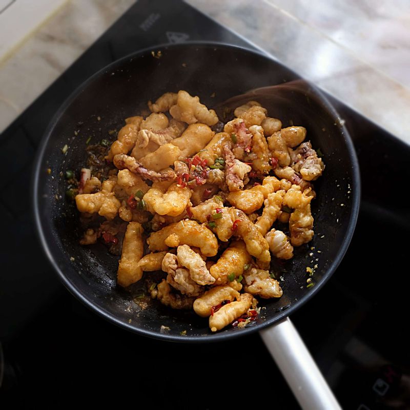 소스가 바글바글 끓으면 튀겨놓은 오징어를 넣어 재빨리 버무려주고, 마지막에 참기름을 뿌리고 송송 썬 실파와 마늘칩, 통깨를 뿌려주세요.