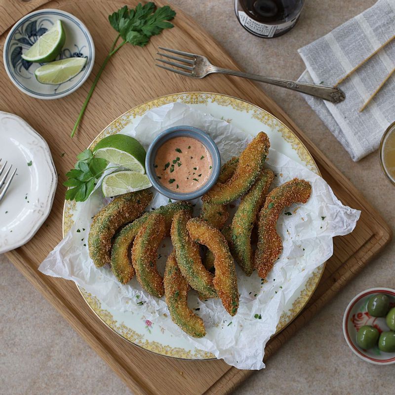 접시에 아보카도 튀김을 담고 파슬리가루를 뿌린 후 딥소스와 레몬(또는 라임)을 곁들여주세요.