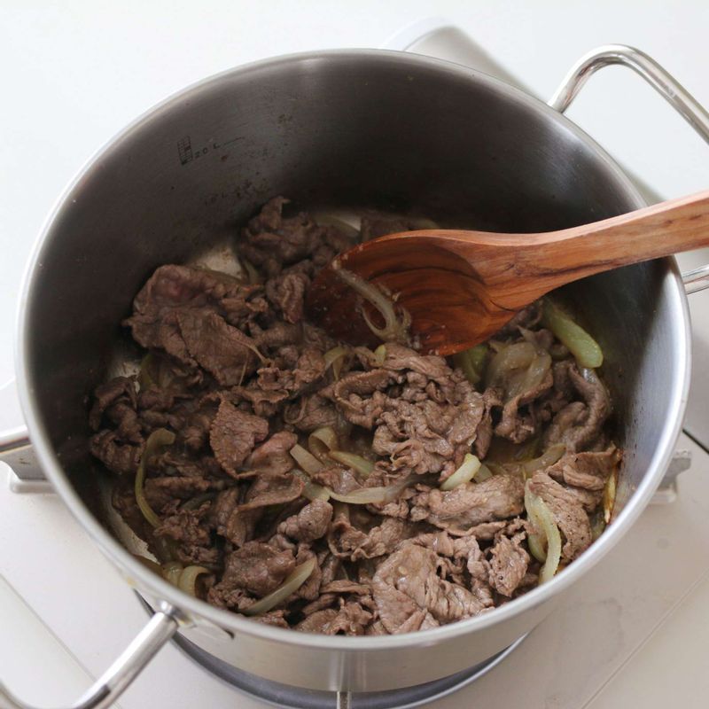 쇠고기는 키친타올에 올려 핏물을 제거한 후 먹기 좋은 크기로 썰고, 양파는 채를 썰고, 대파는 4센치 길이로 가늘게 채를 썰어주세요.
달군 냄비에 버터를 넣고 녹인 후 양파를 넣어 2분간 볶다가 쇠고기, 다진마늘을 넣고 약간의 소금과 후추를 뿌려 2분간 익혀주세요.