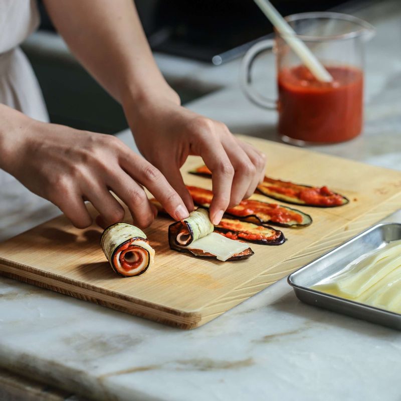 구운가지에 토마토소스를 바르고, 잘라 둔 모차렐라치즈와 함께 돌돌 말아주세요.