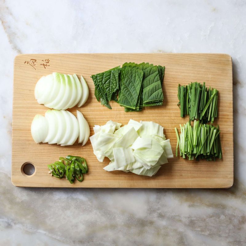 양파는 굵게 채썰고, 양배추와 깻잎은 한 입 크기로 썰어주세요. 부추는 4cm길이로, 청양고추는 송송 썰어주세요