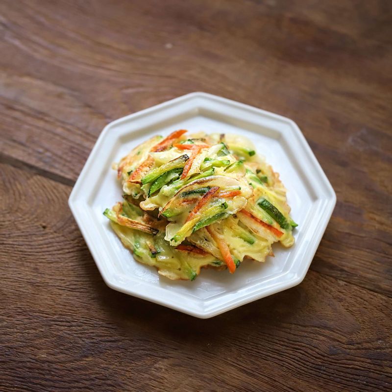 1. 깨끗이 씻은 애호박, 당근, 양파를 채썰어주세요.
2. 볼에 채썬 야채들과 부침가루, 물, 달걀, 소금을 넣어 골고루 섞어주세요.
(Tip! 찬물로 반죽을 해야 더 바삭하게 드실 수 있어요)
3. 달군 팬에 넉넉하게 기름을 두르고, 수저로 반죽을 올린 후 동그랗게 모양을 잡아 노릇하게 부쳐주세요.
4. 접시에 애호박채전을 담고 초간장을 곁들여주세요.
(초간장 재료- 간장 1큰술, 식초1/2큰술, 물 2큰술, 청양고추 1개)