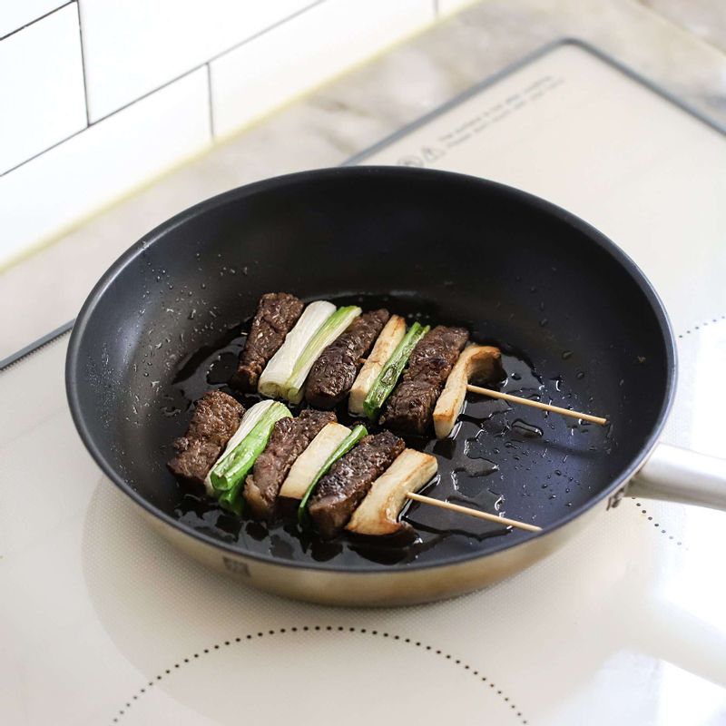 달군팬에 기름을 두르고, 쇠고기 산적 꼬치를 중약불에서 앞뒤로 익혀주세요.