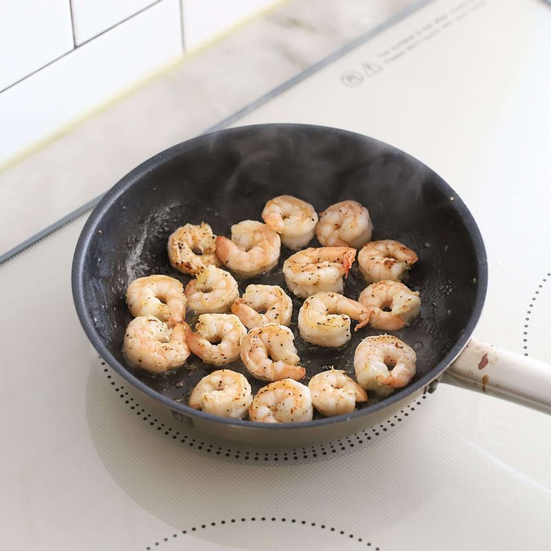 달군팬에 올리브오일을 두르고 손질한 칵테일새우와 소금, 후춧가루를 넣어 새우가 불투명해질 때까지 익혀주세요.