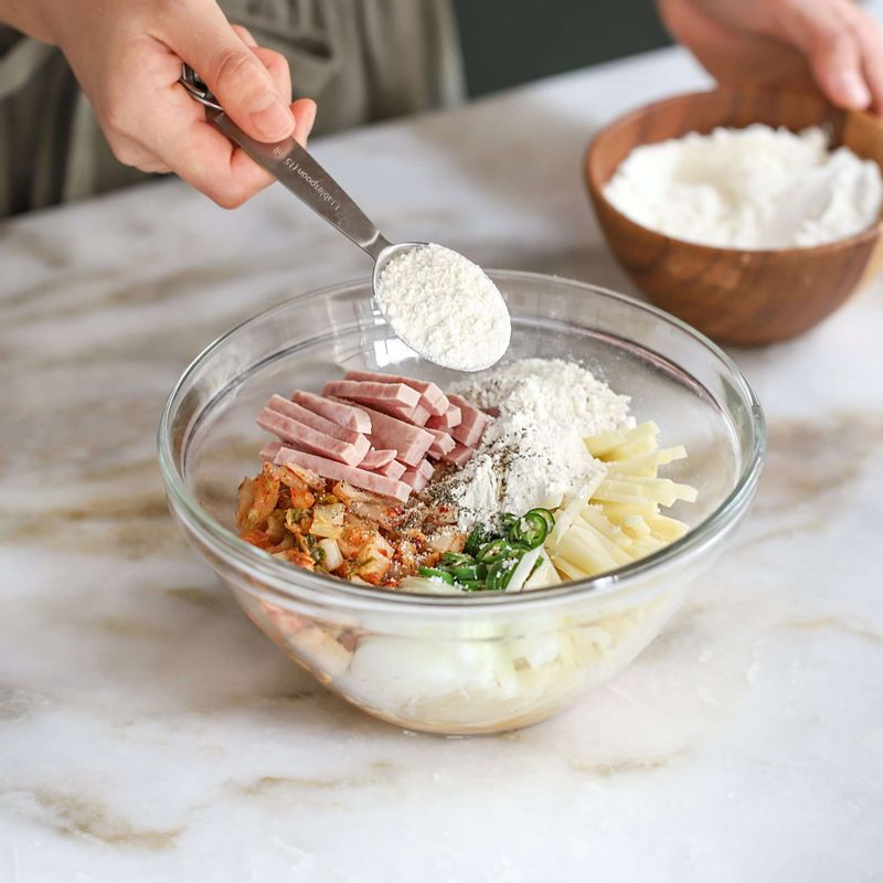 볼에 채썬 야채, 스팸, 김치를 넣고 반죽재료를 넣어 섞어주세요.