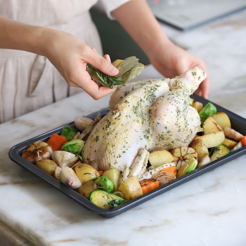 닭에 로즈마리버터를 앞뒤로 바른 후 오븐 팬에 구운 야채와 함께 올려주세요. 로즈마리와 월계수잎을 올린 후 200도로 예열한 오븐에 50분정도 구워주세요.