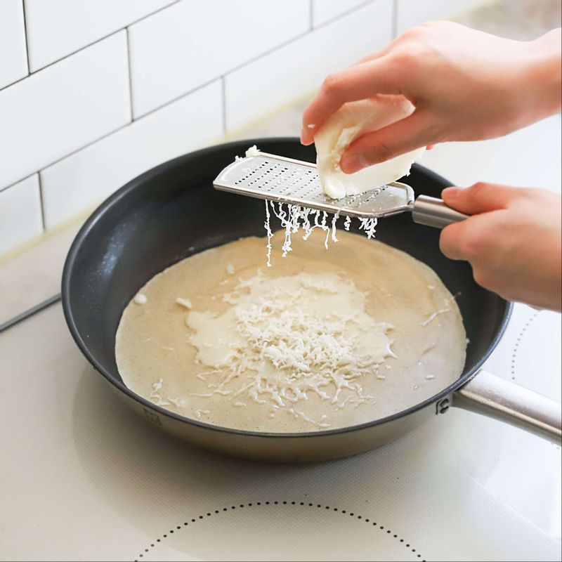 아랫면이 살짝 익으면 가운데에 치즈를 뿌린 후 달걀 1개를 깨서 올리고 후춧가루를 뿌려주세요. 구운 베이컨, 양송이 버섯을 올려주세요.