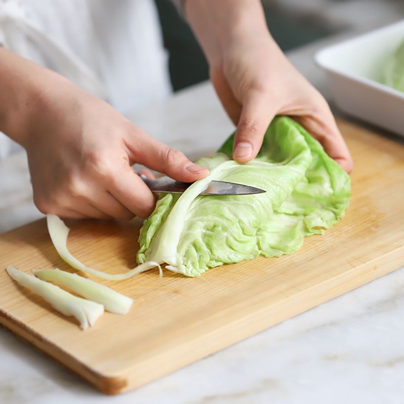 끓는 물에 양배추잎을 넣고 1분 정도 데친 후 찬물에 넣어 식혀 가운데 두꺼운 줄기를 제거해주세요.