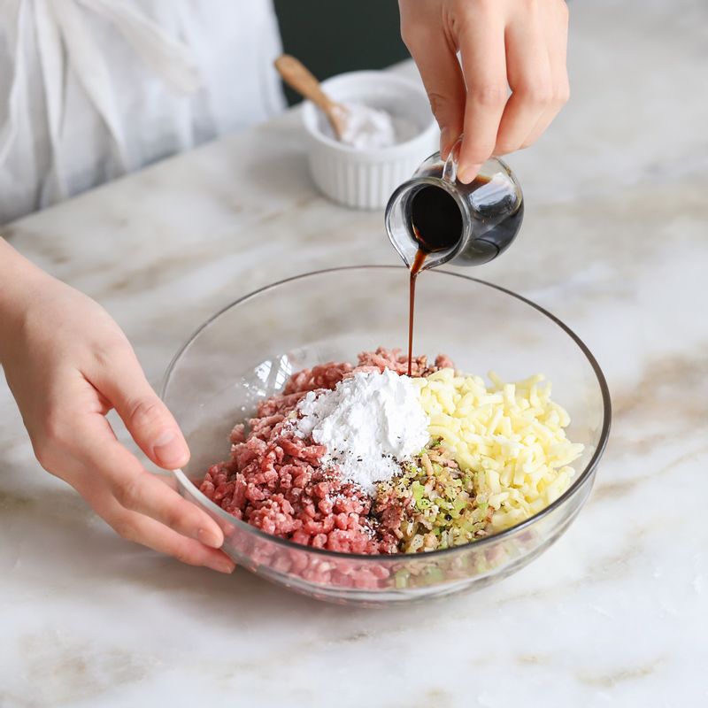 볼에 다진 쇠고기와 돼지고기를 넣고 볶은 양파, 샐러리, 마늘, 베이컨과 모차렐라치즈, 양배추 속 양념재료를 넣어 섞어주세요