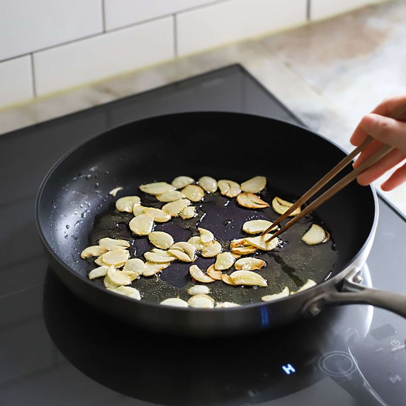 달군팬에 올리브오일을 살짝 두른 후, 중약불에서 마늘편을 넣어 2분 정도 볶아주세요.