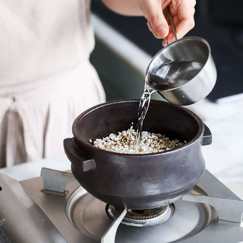 냄비에 불린 쌀과 불린 현미, 물을 넣고 뚜껑을 닫아 센불에서 끓이다가 끓어오르면 약불로 줄여 10~15분 정도 더 끓여주세요.